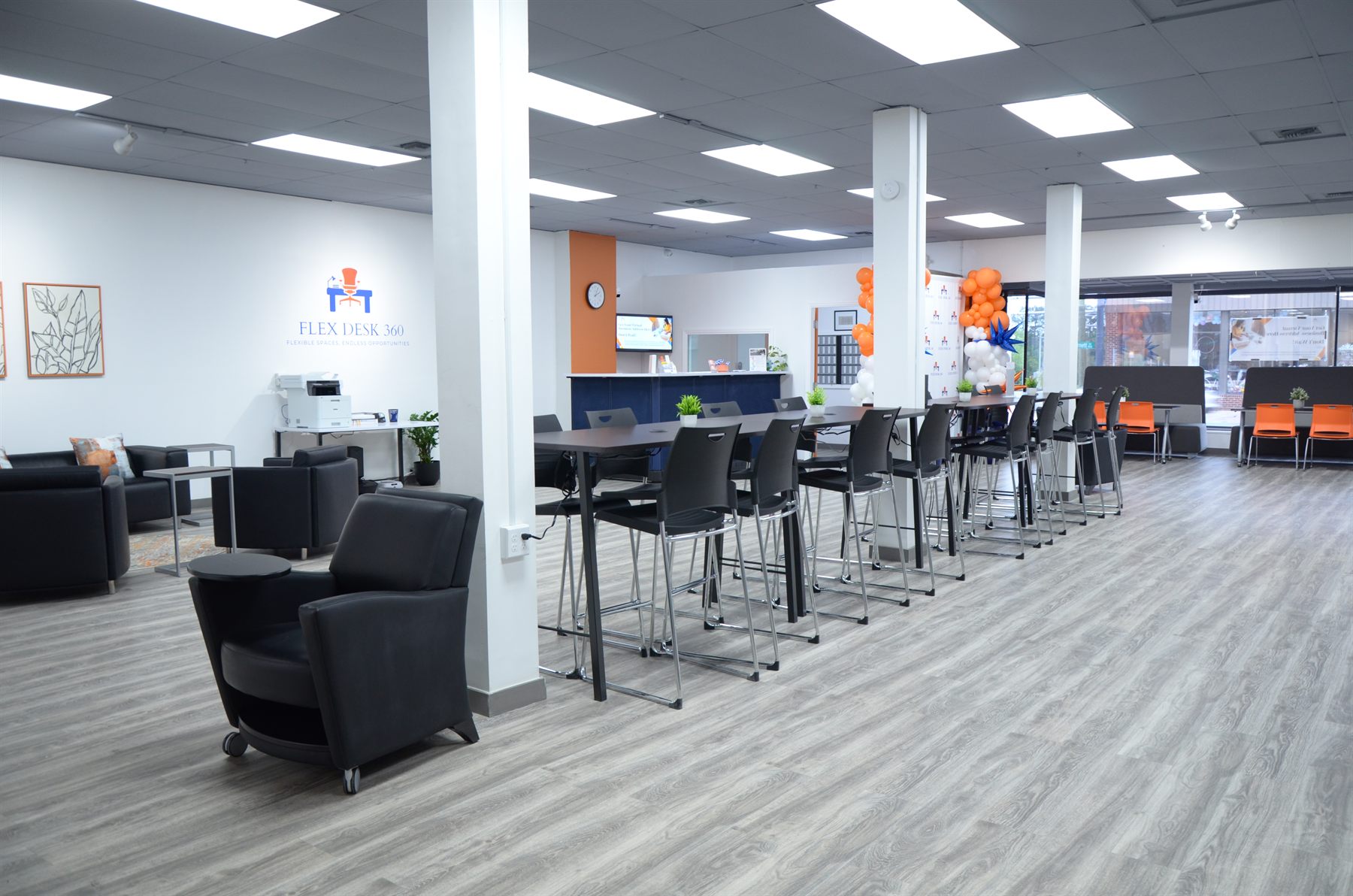 Open coworking floor at Flex Desk 360 with desks, chairs, and natural light